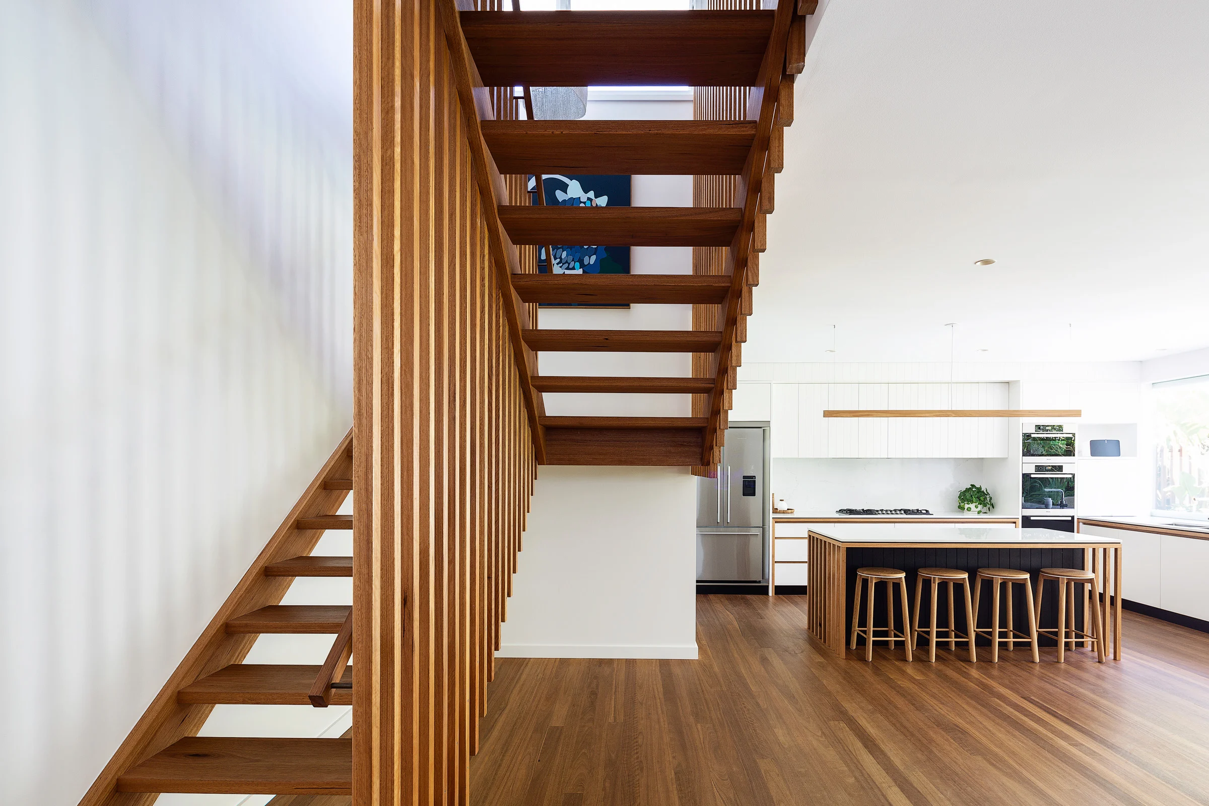 Staircase and kitchen of a property in Avalon Beach, Sydney designed by Byron Bay architects Markham Lee.