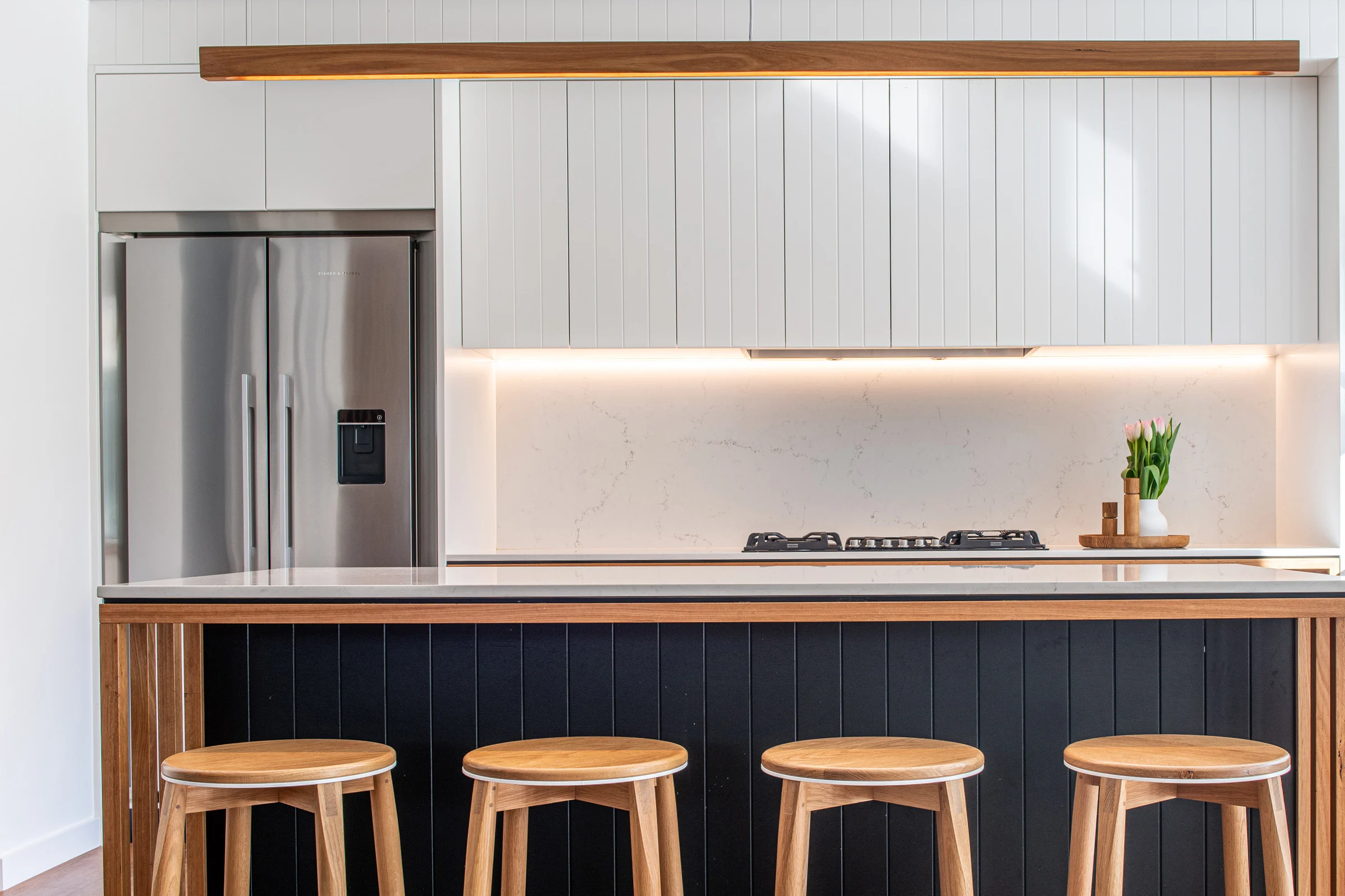 Kitchen counter with stools of a property in Avalon Beach, Sydney designed by Byron Bay architects Markham Lee.