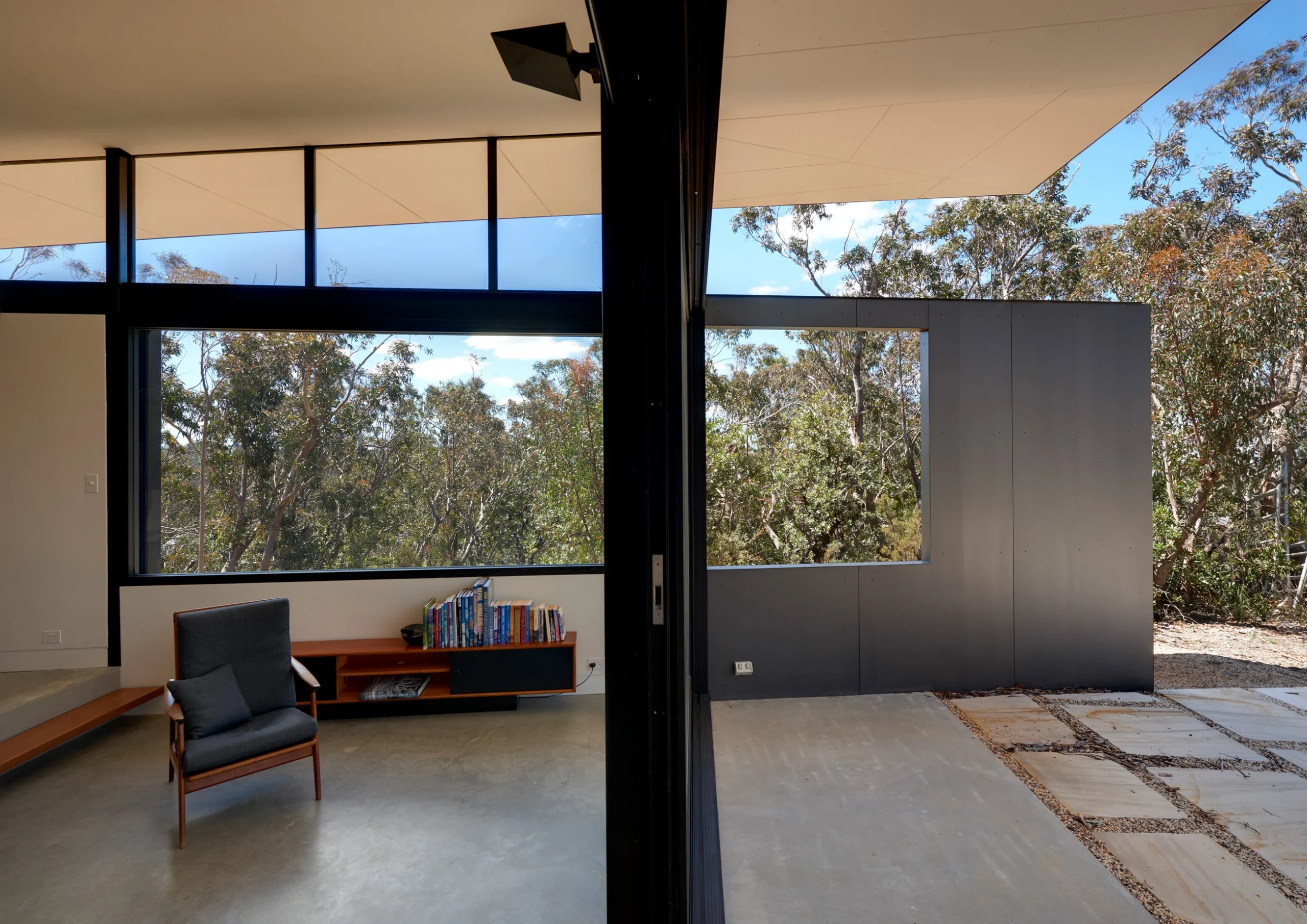 Lounge room and patio of a bushfire-proof property in Leura, Blue Mountains designed by Northern Beaches architects Markham Lee.