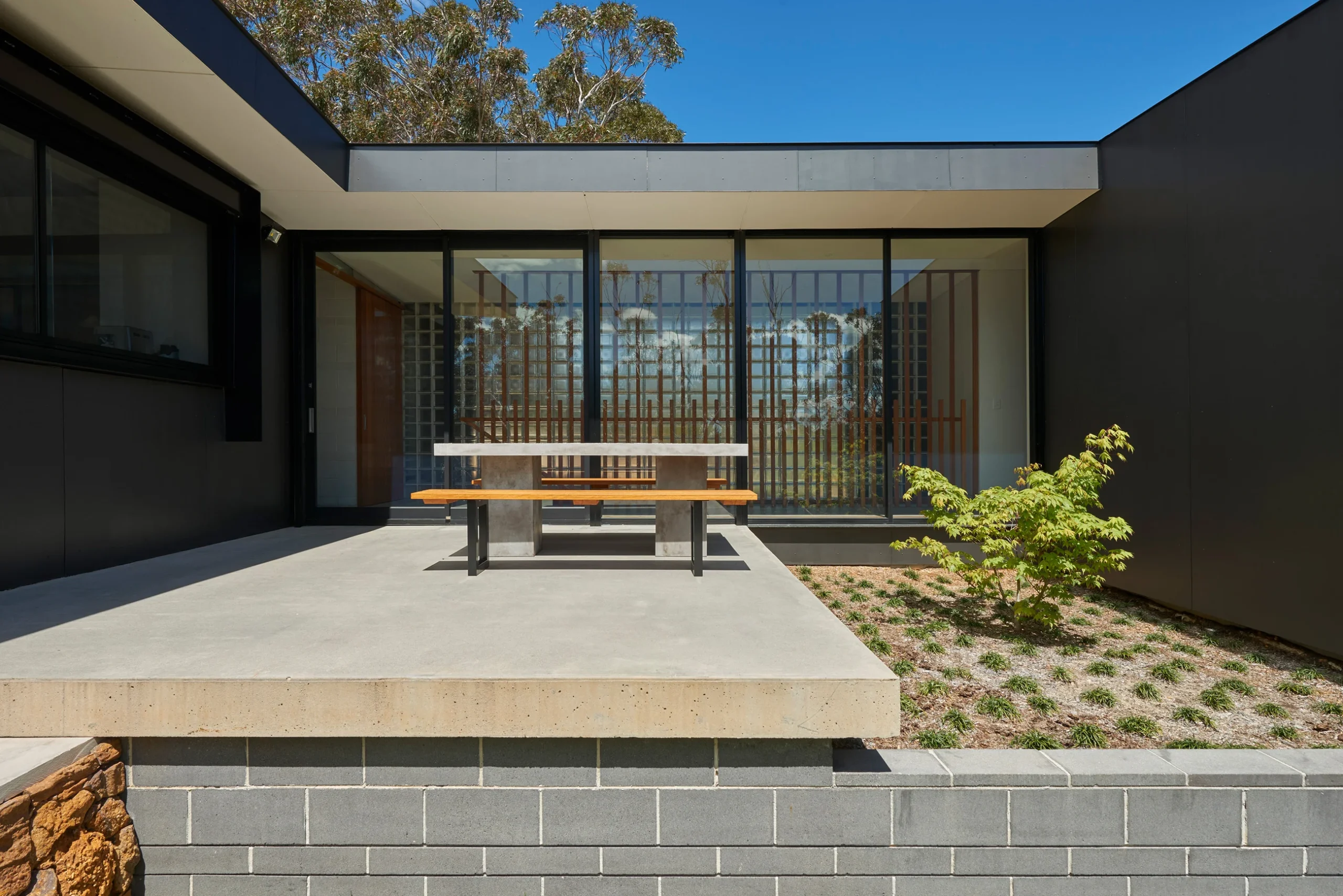 Patio and garden of a bushfire-proof property in Leura, Blue Mountains designed by Northern Beaches architects Markham Lee.