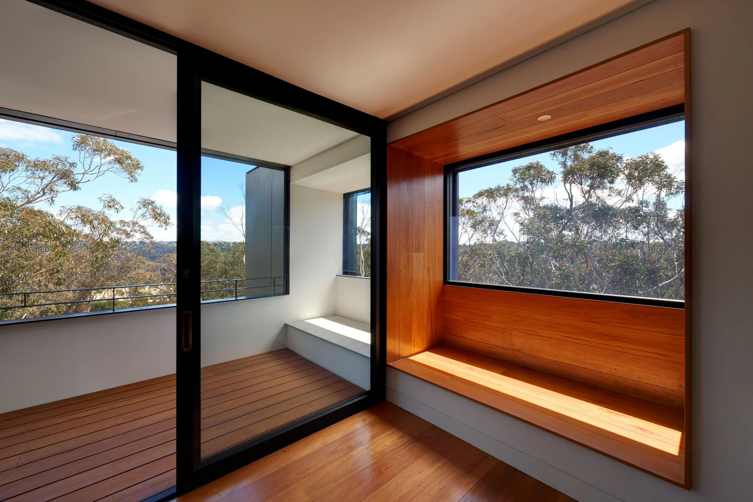 Interior with a view to a balcony of a bushfire-proof property in Leura, Blue Mountains designed by Northern Beaches architects Markham Lee.
